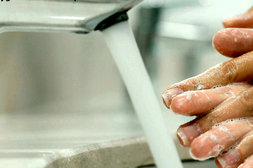 Hands being washed under a running tap with a rich lather